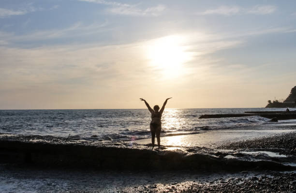Silhouette of a woman at sunset, on the background of the sea