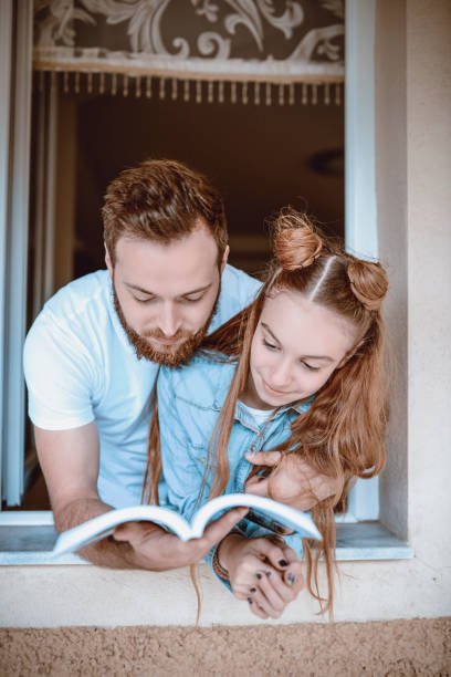 istock Uncle Reading Funny Story To a Girl 1128006608