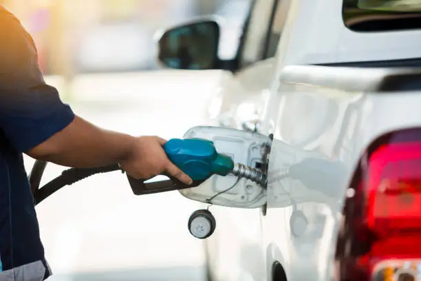 Photo of Hand refilling the white pickup truck with fuel at the gas station