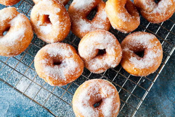 Close-Up Of A Bunch Of Homemade Donuts On A Cooling Tray stock photo