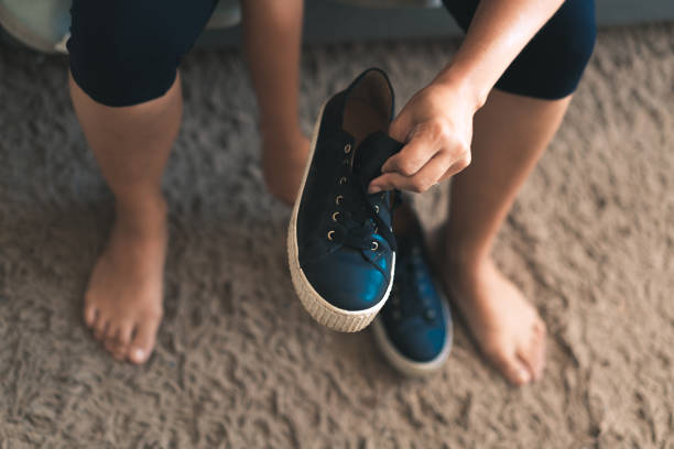 istock Sportswoman putting on trainers 1128011296