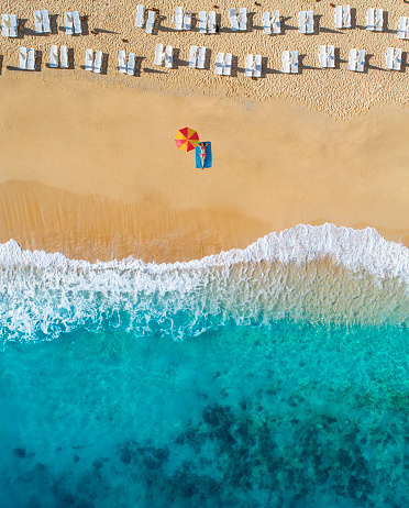 Aerial view of enjoying at beach woman and  clear turquoise water of mediterranean sea.