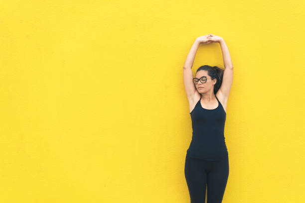 atleta donna allenamento su sfondo giallo - posizione corretta foto e immagini stock