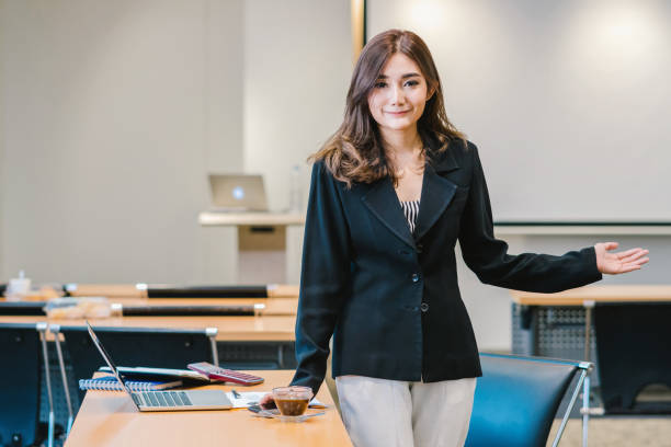 portrait de femme d’affaires asiatique en costume casual debout en geste ou action présente dans les bureaux modernes ou salle de réunion ou salle de séminaire, propriétaire de l’entreprise et concept de l’entrepreneur - computer business office occupation photos et images de collection