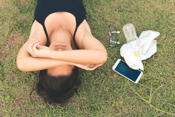 Exhausted athlete lying on the grass Women, Athlete, Sportsperson, The Human Body, People fainted stock pictures, royalty-free photos & images