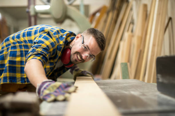 istock Creative carpenter checking smoothness of wood material. Smiling woodworker preparing planks for work. 1128014150
