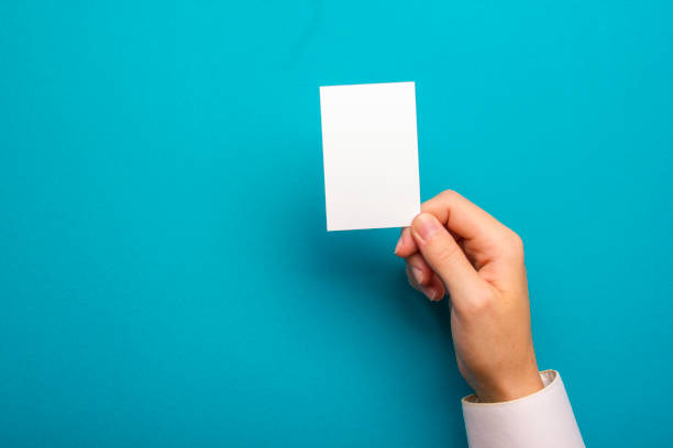 istock Hand holding white business card on white background 1128015618