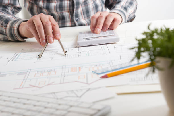 architects working on blueprint, real estate project. architect workplace - architectural project, blueprints, ruler, calculator, laptop and divider compass. construction concept. engineering tools. - housing project organization meeting real estate imagens e fotografias de stock