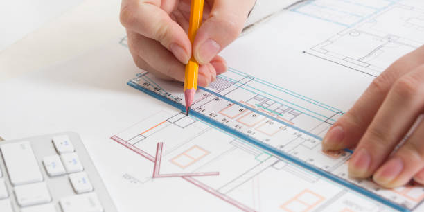 arquitetos, trabalhando na planta, projeto imobiliário. arquiteto no local de trabalho - projeto arquitetônico, plantas, régua, calculadora, laptop e divisor de bússola. conceito de construção. ferramentas de engenharia. - housing project organization meeting real estate - fotografias e filmes do acervo