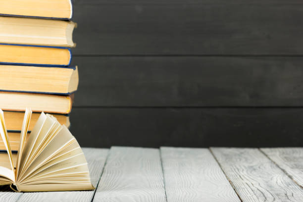 istock Open book, hardback books on wooden table. Back to school. Copy space 1128016349