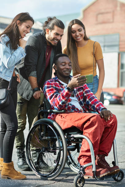 istock Disabled man watching photos with friends on phone 1128016355
