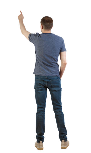 istock Back view of a man in jeans points his hand upwards. 1128017271
