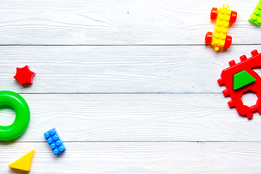 Colorful kids toys frame on wooden background. Top view. Flat lay. Copy space for text