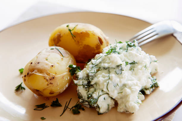Hot potatoes boiled in their skin and curd cheese (quark) with herbs. Healthy Hay diet, low carb diet, keto diet recipe. stock photo