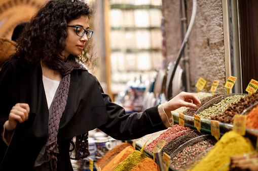 Woman shopping in spice shop in Grand Bazaar, Istanbul, Turkey