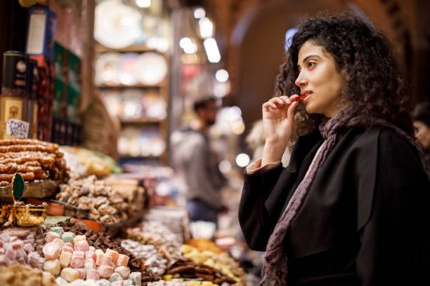 joven mujer de compras en la tienda de delicias turcas en gran bazar, estambul, turquía - tasting women eating expressing positivity fotografías e imágenes de stock