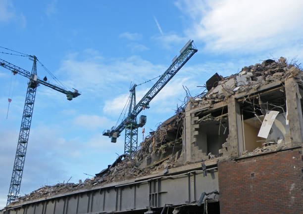 excavation bucket working at the demolition of an old garden building