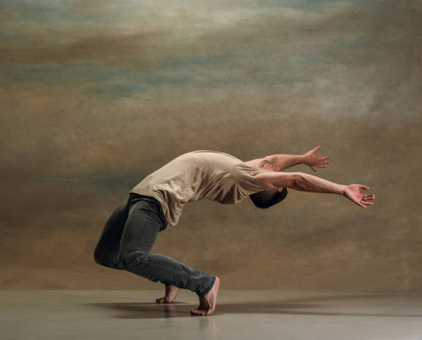 молодой человек танцует на сером - ballet people dancing human foot стоковые фото и изображения