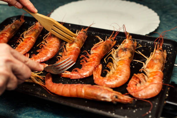 cooking tiger shrimps on iron griddle - grilled shrimp imagens e fotografias de stock