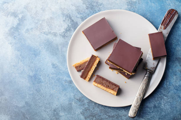 istock Chocolate caramel slices, bars, millionaires shortbread on a grey plate. Blue background. Top view. 1128027042