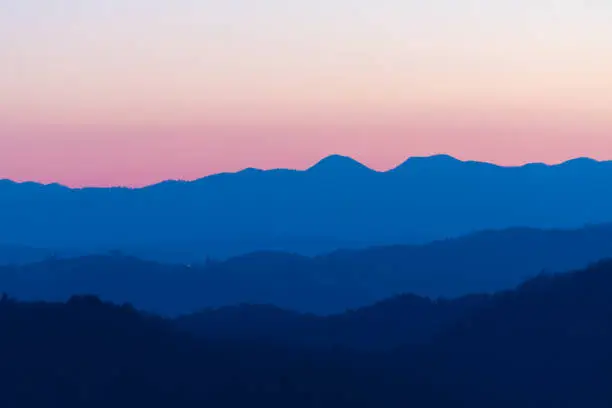 Photo of Beautiful pink and blue color nuances of twilight sky and hills after sunset