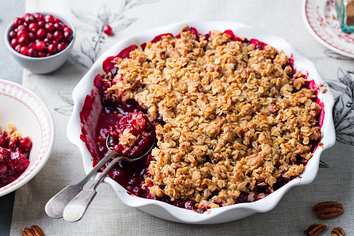 Cranberry crumble, crisp in a baking dish. Grey background. Close up