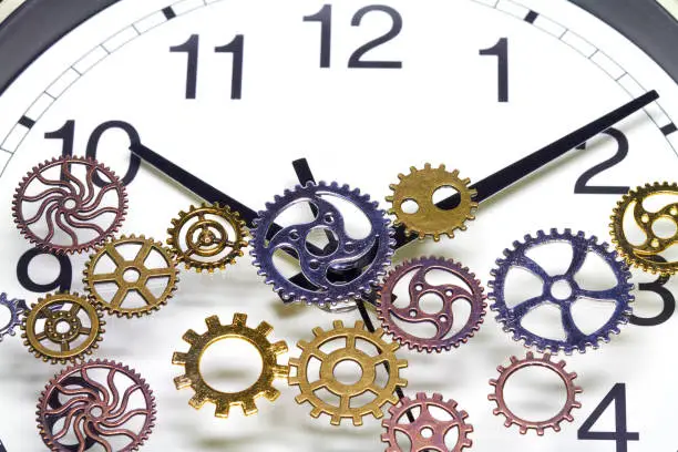 Cogs lie on the dial of a clock.