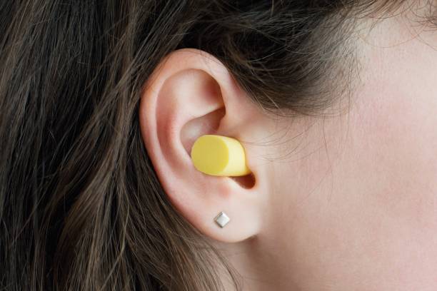 Woman's ear with an ear plug, noice  reduce, noice pollution . Noice pollution ear plug stock pictures, royalty-free photos & images