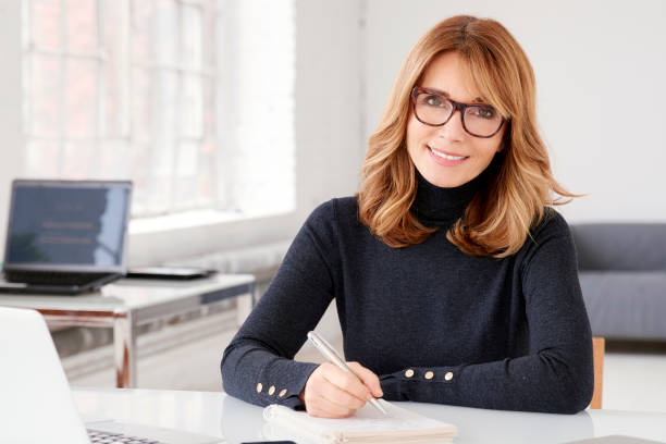 istock Businesswoman sitting at office desk and doing some paperwork 1128036068