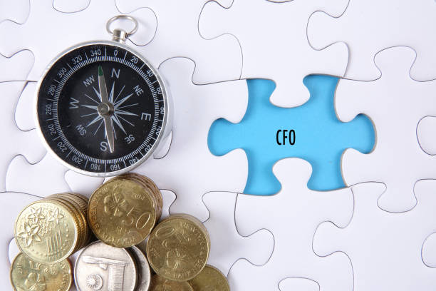 Close-Up Of Compass And Coins On Jigsaw Puzzle With Text  cfo stock pictures, royalty-free photos & images