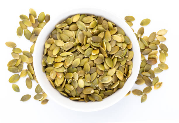 istock Pumpkin seeds (peeled seeds) in white bowl (Various nuts collection). Isolated on white background. 1128037642