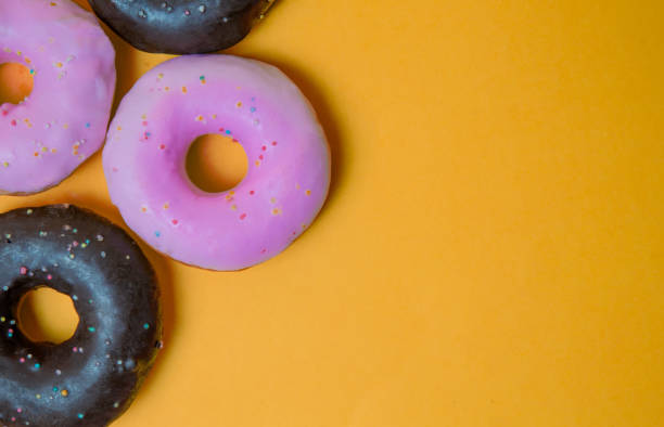 istock donut cover with chocolate and strawberry with yellow background 1128040678