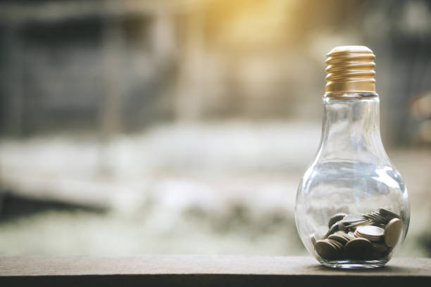 istock Close-Up Of Coins In Light Bulb On Table 1128042985