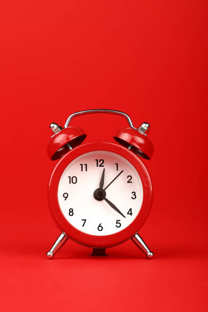 istock Close-Up Of Clock Against Red Background 1128044509