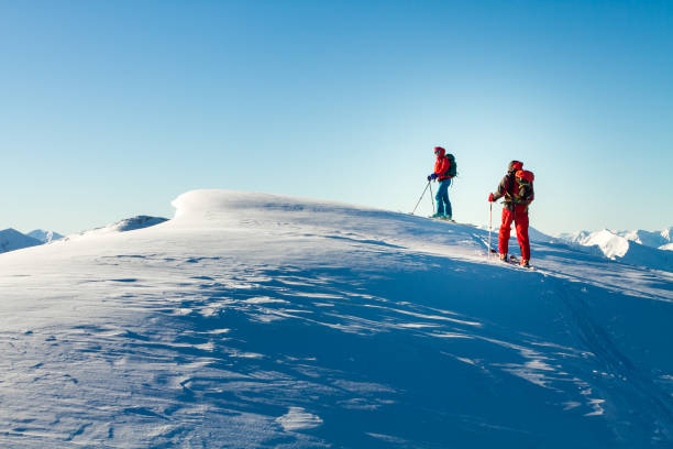 мужчина и женщина лыжный tourer наслаждаясь видом на вершину в альпах. - skitour стоковые фото и изображения