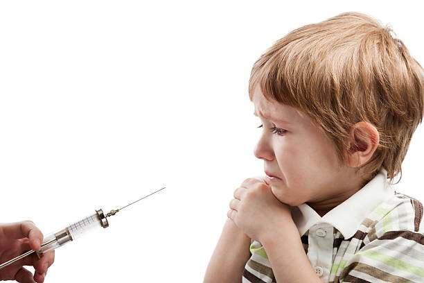 A scared boy about to receive an injection on his arm