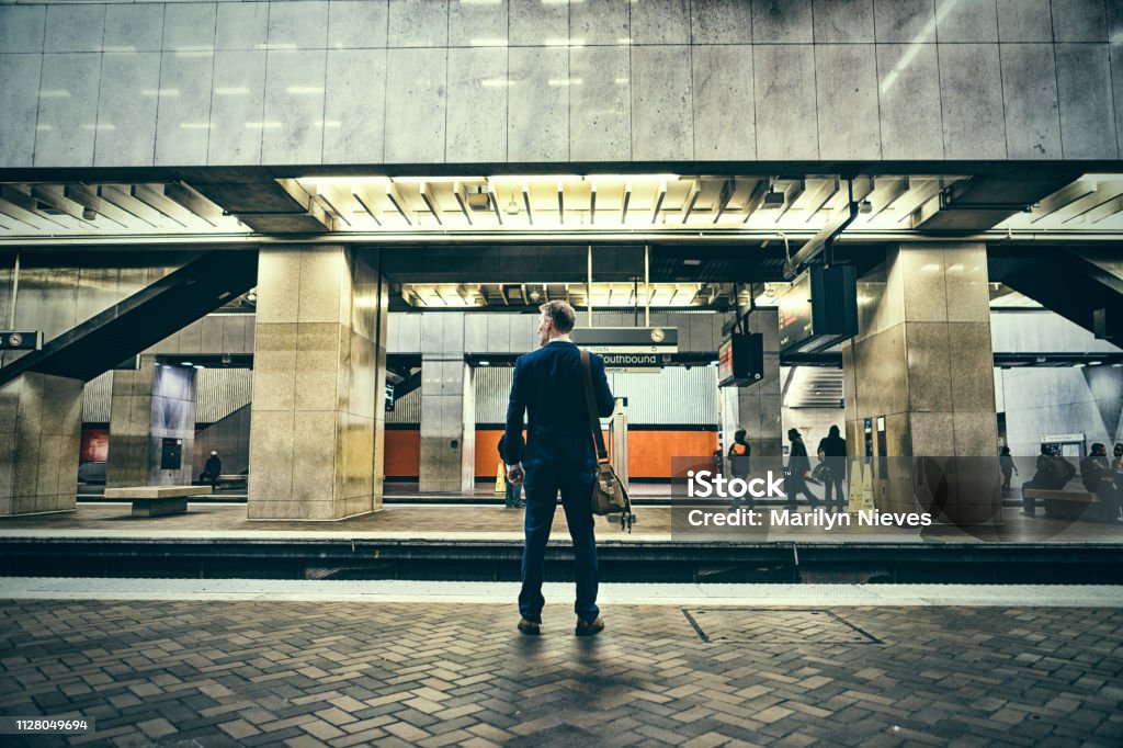businessman on a journey Businessman stands by train platform Railroad Station Platform Stock Photo