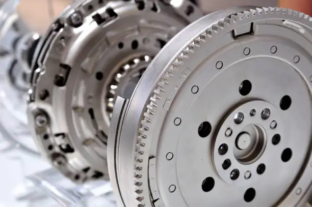 Photo of Car flywheel with a clutch in backgroung, with selective focus.