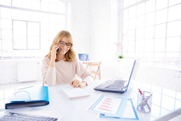 istock Businesswoman making a call while working on laptop in the office 1128052657