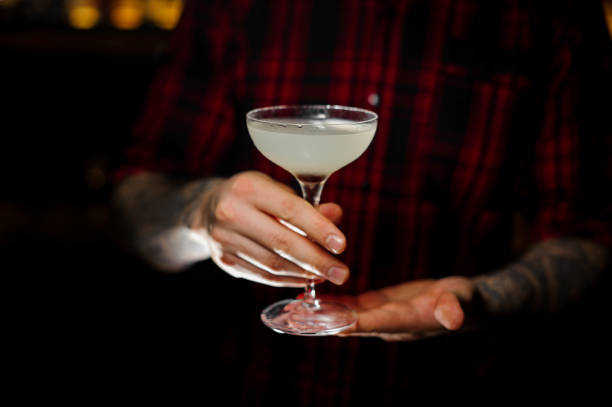 istock Bartender serving a glass of a Courpse Reviver cocktail on the bar counter 1128052756