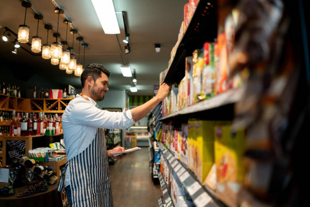 istock Handsome salesman at a food store preparing a delivery while looking at list on notepad smiling 1128053962