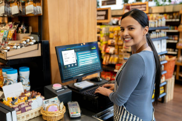 istock Beautiful cashier at a grocery store facing camera smiling 1128054007