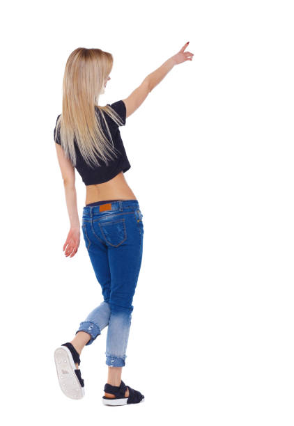 istock Side view of a girl walking with a pointing hand. 1128054109