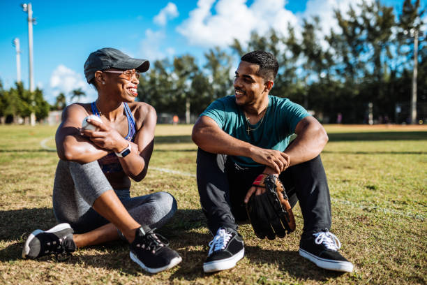 pareja latina de citas y el coqueteo después de jugar al juego de béisbol en estados unidos - puertorriqueño fotografías e imágenes de stock