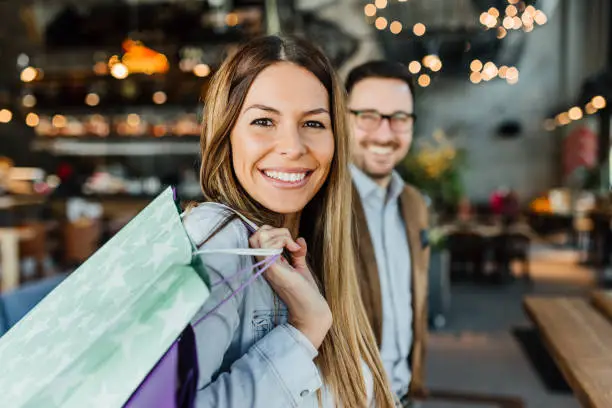 Happy attractive loving couple enjoy shopping together