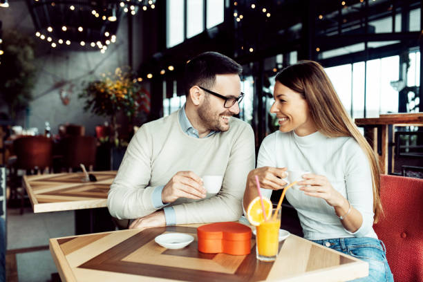 istock Young attractive couple on date in coffee shop 1128057729