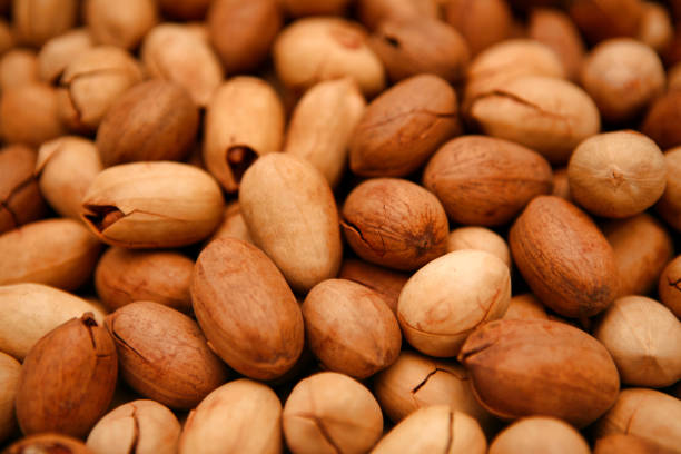 istock Unpeeled pecans lie on the counter close-up. 1128059598