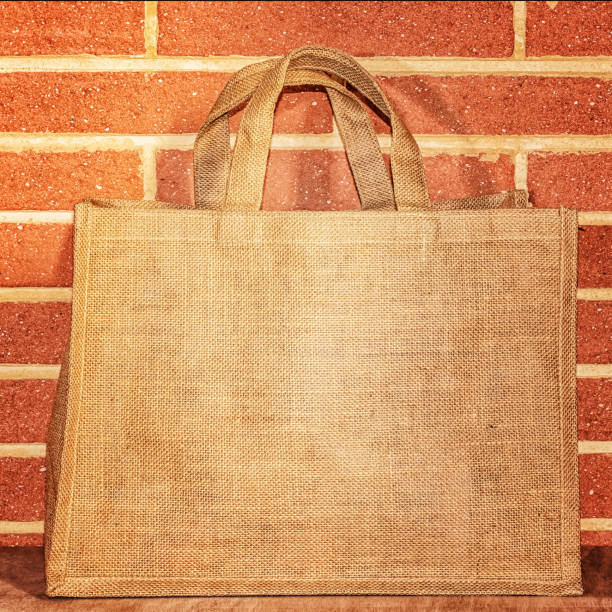 istock Bag for products from natural burlap with handles against a brick wall. 1128060881