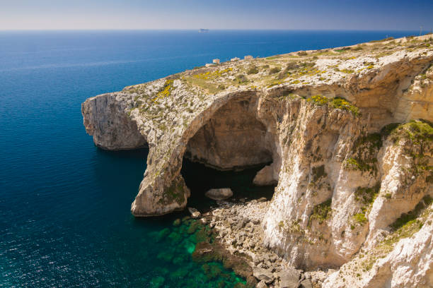 Blue Grotto sea arch, Malta Malta - Qrendi - Dramatic massive natural stone arch Blue Grotto (Taht il-Hnejja) near Wied iz-Zurrieq on the south coast of Malta island grotto cave photos stock pictures, royalty-free photos & images