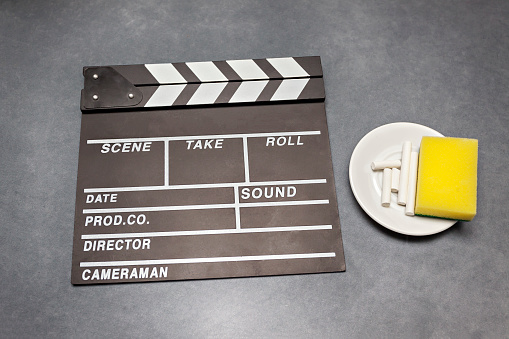 Movie clapper board with chalk and sponge on gray background - film, cinema and video photography concept